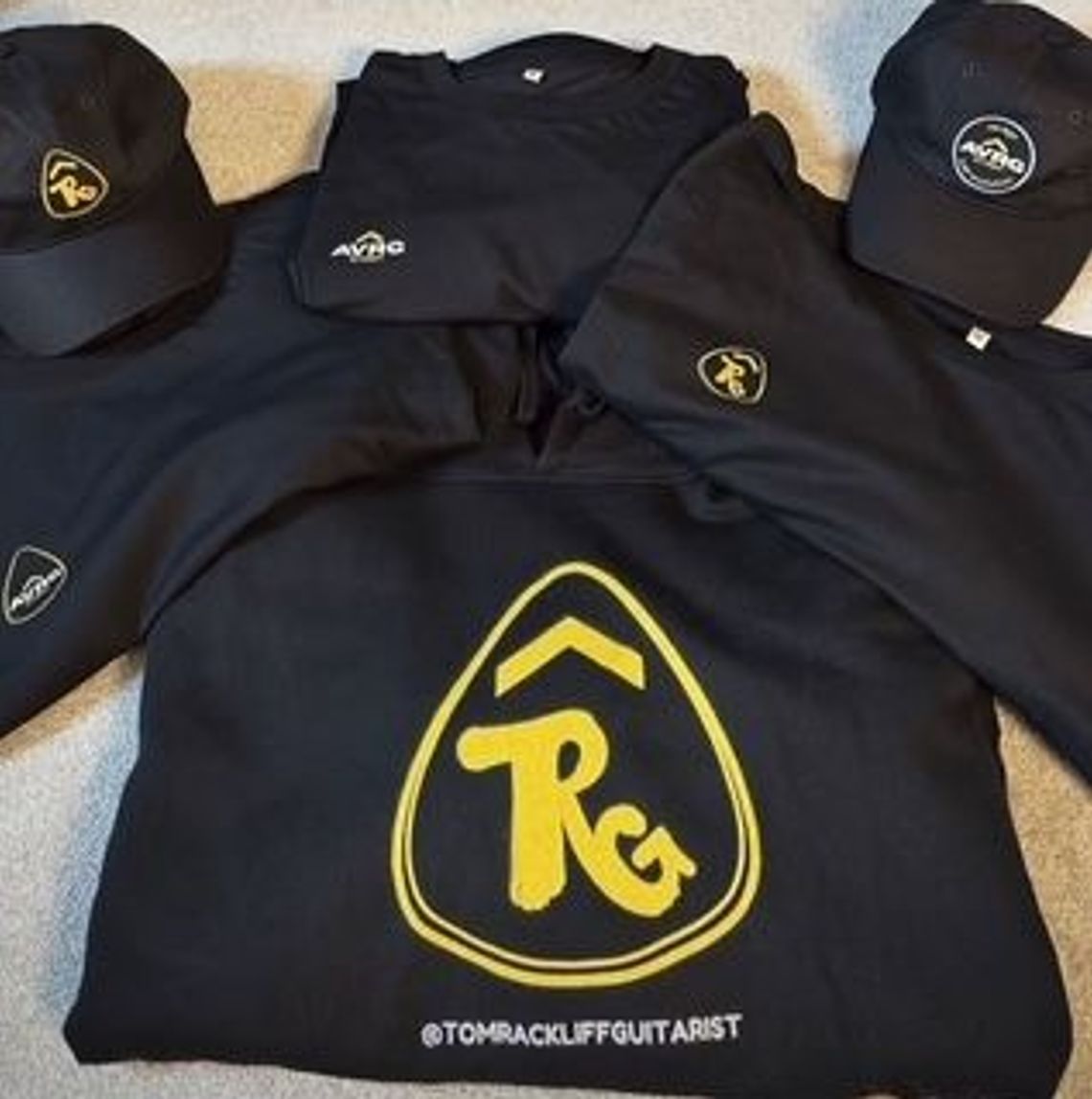 Above Average sustainable clothing or Tom Rackliff, a touring and session guitarist. The picture shows a custom design hoodie and tee and some ABove Average GTRST tees and caps