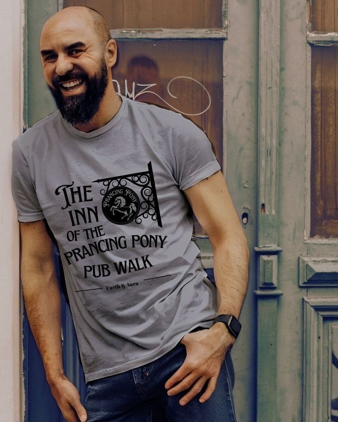 A man leans on a wall and grins, wearing a lord of the rings T-shirt A man leans on a wall and grins, wearing a lord of the rings T-shirt